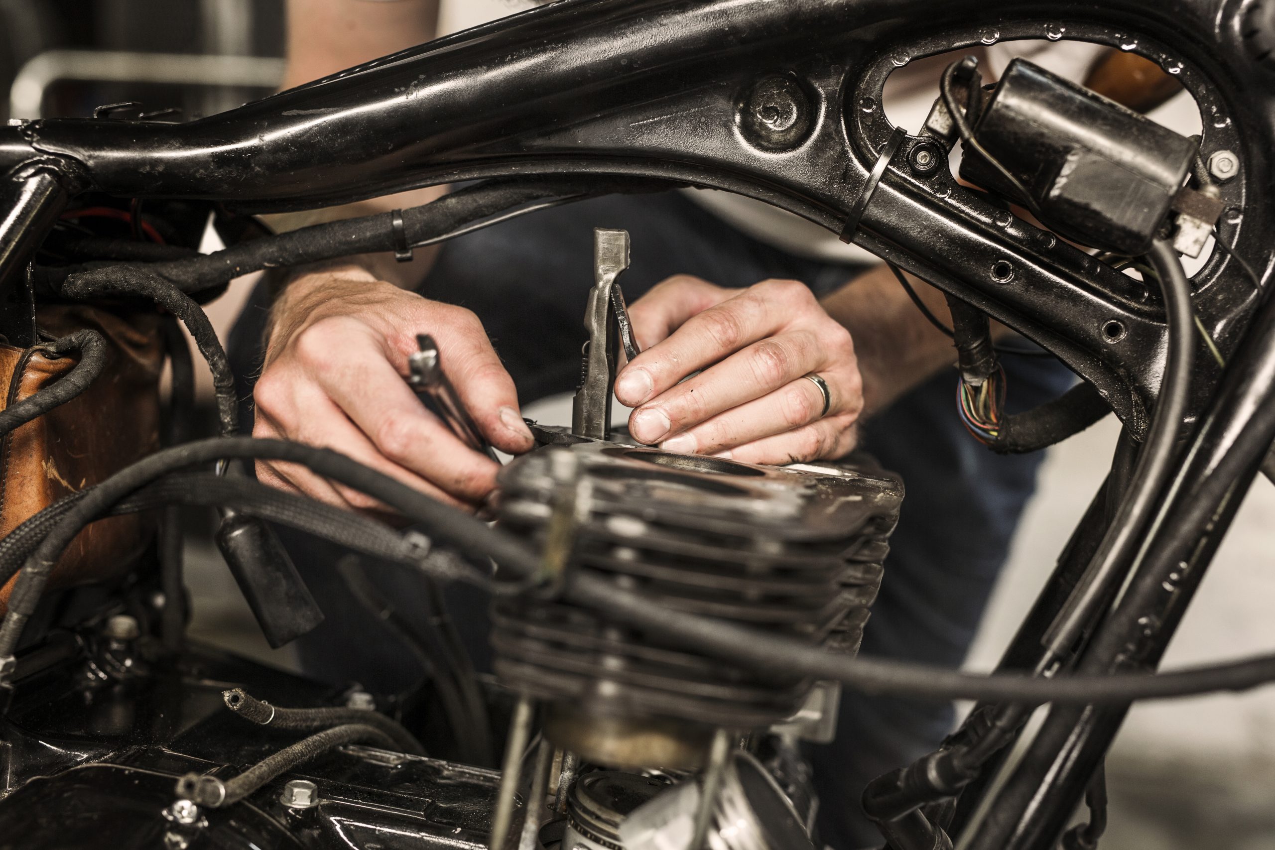 Person arbeitet an einem Motorrad.